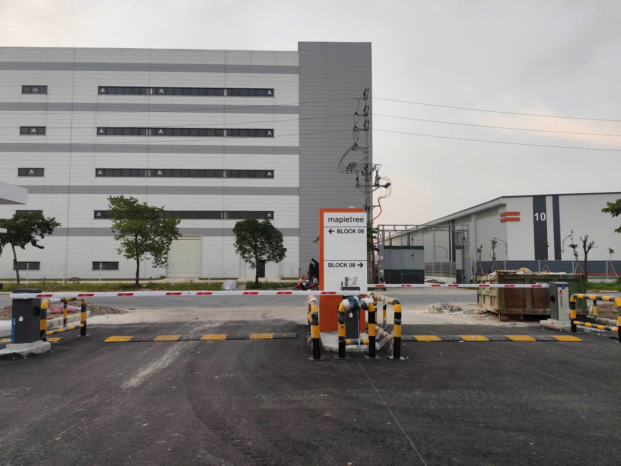 Cổng vào khu công nghiệp Mapletree với barie chắn xe và biển chỉ dẫn block 08, block 09